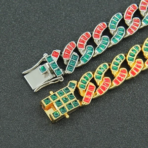 Detail of gold and silver hip hop Cuban bracelets with red and green enamel accents