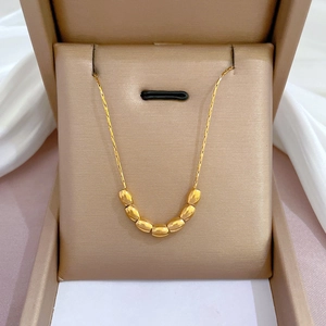 Close-up of gold titanium steel necklace with small oval beads in a premium jewelry box