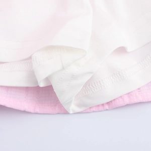 Tiered ruffle mini skirt featuring white knit layer and pink woven fabric texture