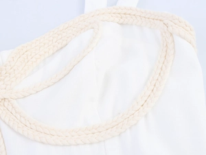 Detailed close-up of white cotton fabric texture and beige woven rope trim on dress neckline