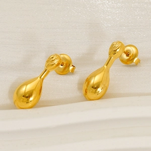 Elegant gold-tone drop earrings with a polished finish on white marble and silk