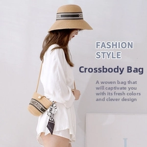 Detail of beige straw crossbody bag with pearl clasp and stylish wood handle