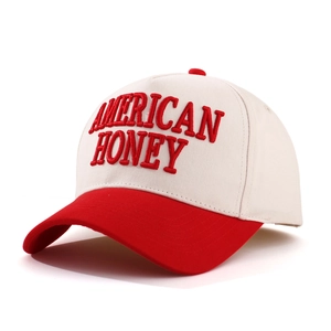 Macro view of red 3D AMERICAN HONEY embroidery on a cream and red baseball cap