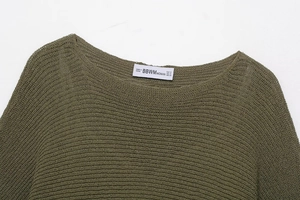 Close-up of olive green knitted top neckline with size label and crochet texture