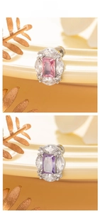Detail of titanium steel earrings with pink and purple zircons on warm display