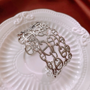 Detailed macro view of silver hollow chain link open bangle with woven design