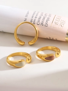 Detailed view of minimalist teardrop 18K gold plated rings with cream and coffee enamel