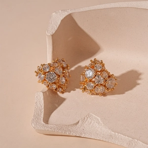 Close-up of heart-shaped zircon earrings on a luxury beige geometric display stand