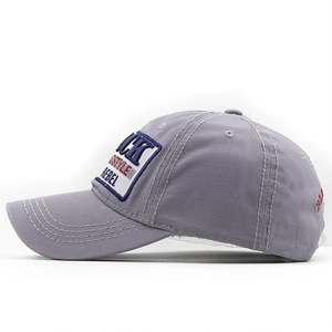 Detail of gray baseball cap featuring vintage patches and CK STYLE REBEL embroidery