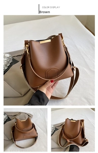 Detail view of brown PU leather bucket bag with gold metal trim and striped strap