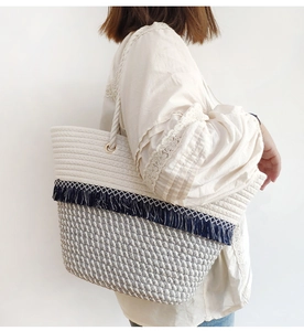 Detail view of large bohemian cotton rope tote with fringe trim and woven handle
