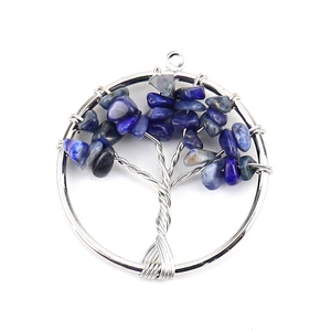 Detailed close-up of Tree of Life pendant with blue crystal stones and silver wire wrap