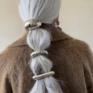 Detail of vintage silver double-layer elastic hairpins on braided grey hair