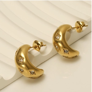 Detail of gold-plated chunky C-hoop earrings featuring starburst set cubic zirconia stones