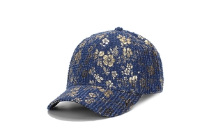 Dettaglio della trama del cappellino in tweed blu navy con stampa floreale dorata