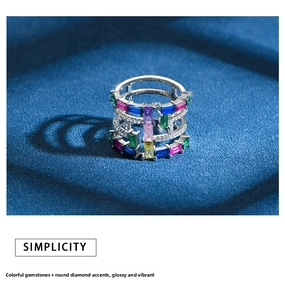 Macro shot of multi-layered silver ring with colorful rectangular zircons and round diamonds