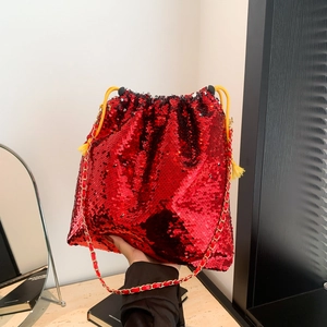 Macro shot of red sequin bucket bag with gold chain strap and yellow drawstring details