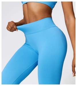 Detail of high waisted compression yoga pants with ribbed waistband in bright blue color