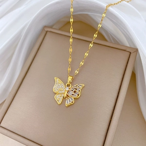 Détail du pendentif papillon avec cristaux clairs sur chaîne dorée en écrin