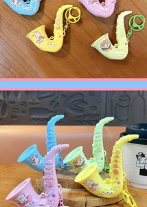 Macro view of colorful plastic saxophone keychains featuring cute cartoon animal prints.