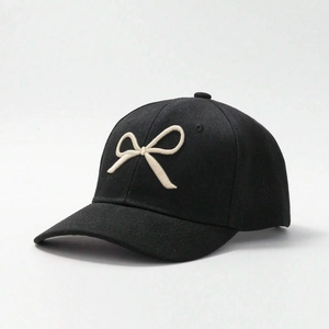 Close-up of cream bow embroidery on high-quality black cotton twill baseball cap