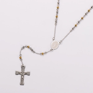 Close-up of golden and silver bead chain with Virgin Mary medal and crucifix pendant