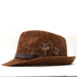 Detail of brown hand-woven straw hat with leather band and golden metal buckle