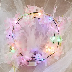 Detail of pink LED flower crown with string lights and battery box on white tulle