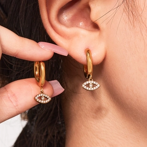 Gold-plated stainless steel devil eye earrings with white zircon on a model
