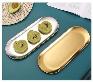 Macro detail of oval gold stainless steel tray holding matcha rolls on a green desk