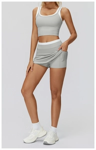 Detail showing the gray high-waisted tennis skirt with side pockets and ribbed sports top