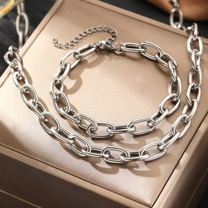 Silver stainless steel oval link chain necklace and bracelet set on jewelry box