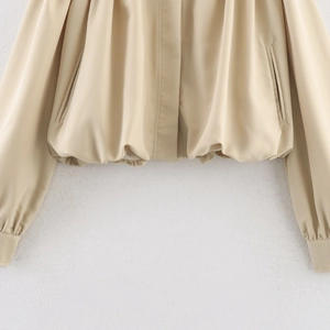 French retro beige jacket with gathered elastic hem and pocket details on light background