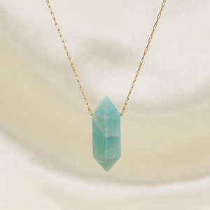 Minimalist gold necklace featuring a hexagonal Amazonite stone pendant on light fabric
