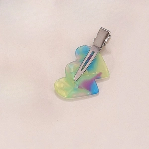 Detailed close-up of iridescent heart-shaped acetate hair clip with metal fastener
