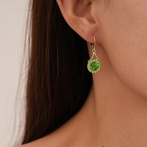 Close-up of lever-back earrings with round emerald green zircon and gold plating