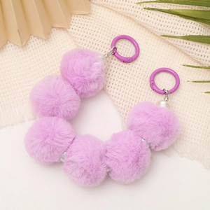 Detail of purple plush faux fur phone strap with white pearl beads and silver metal clasps