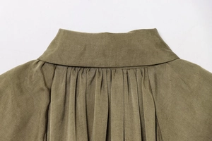 Detailed close-up of military green bomber jacket collar with fine pleated fabric texture