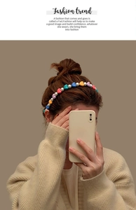 Close-up of a stylish pearl and colorful heart-beaded headband worn by a model