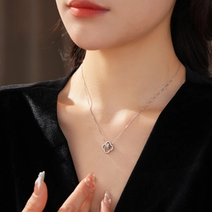 Detail of silver hollow flower pendant necklace with cubic zirconia on model neck