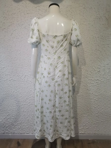 Detailed back view of a white floral dress with puff sleeves and zipper waist closure