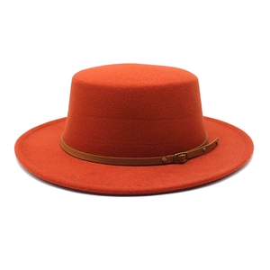 Détail d'un chapeau en laine orange à bord plat avec sangle en cuir brun et boucle