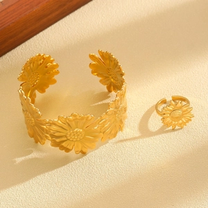 Close-up of golden sunflower stainless steel open bracelet and matching ring set