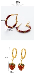Detail view of gold C-shape earrings with strawberry charm and retro enamel hoop