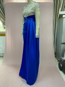Detail of round neck evening dress with silver sequins and blue beaded wave patterns