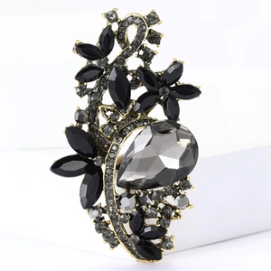 Macro detail of vintage floral alloy brooch featuring gray teardrop stone and crystals