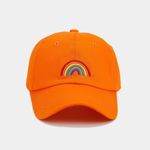 Detailed close-up of rainbow embroidery on a bright orange cotton baseball cap crown