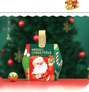 Detail of Christmas gift box with Santa motif and gold handle against holiday bokeh