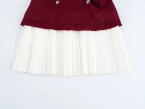 Détail du haut en tweed rouge et de l'ourlet plissé blanc avec boutons décoratifs