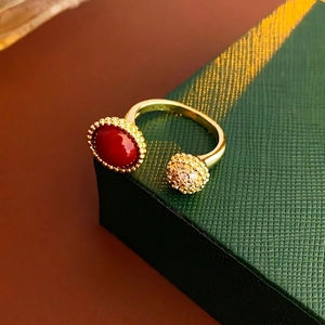 Bague ouverte dorée avec pierre rouge ovale et sphère en zircon sur écrin